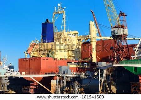 cargo ship during fixing and painting at the shipyard docks