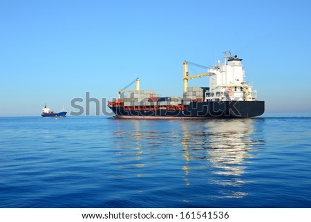 cargo container ship and small cargo ship sailing in still water