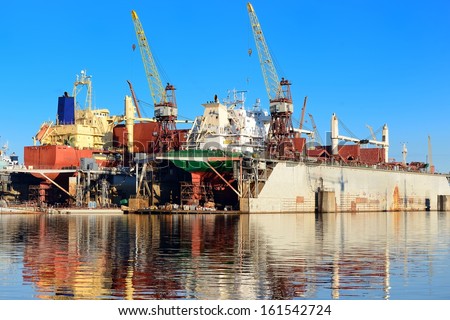 cargo ship during fixing and painting at the shipyard docks