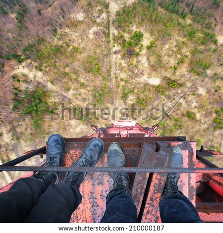 Urban explorers standing at the top of abandoned tower in army boots