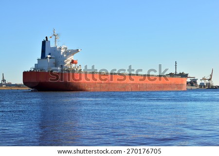 Large cargo ship (Bulk carrier) sailing in a bright sunny day.