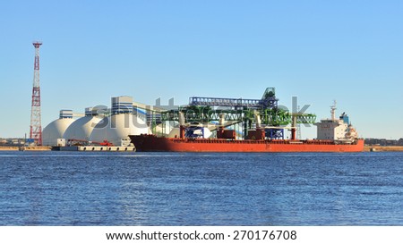 Large cargo ship (Bulk carrier) sailing in a bright sunny day.