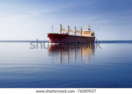 cargo ship sailing in still water near port of Riga