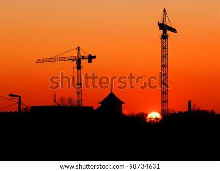 crane and other buildings silhouettes at the sunset
