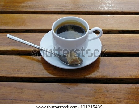 Double espresso coffee in white cup on wooden table