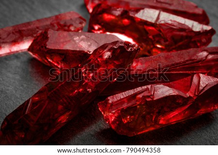 Rubies and raw crystal gems concept with closeup of a bunch of red rough uncut ruby crystals