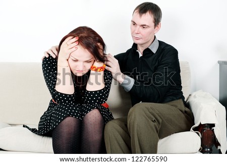 Man comforting his woman on the sofa