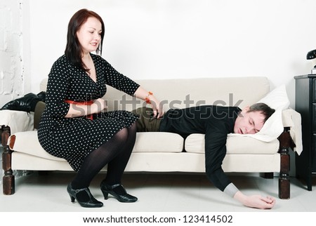 Woman checking telephone of her sleeping man