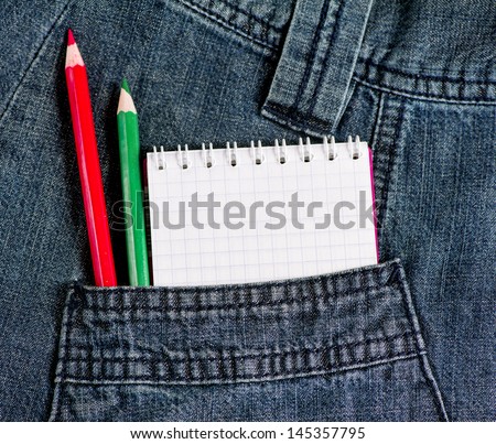 Notebook with red and green pencils in jeans pocket