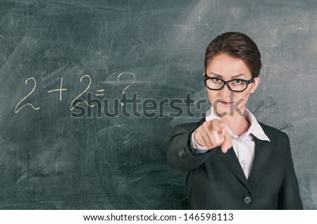 Woman teacher teaching maths and pointing on someone
