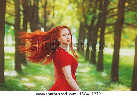 Beautiful woman with red fluttering hair