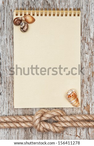 Ship rope, sea shells, notebook and old wood background