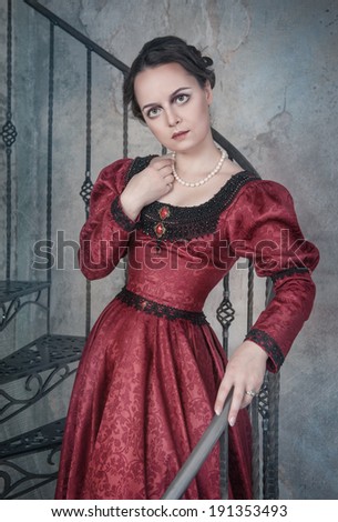 Beautiful woman in medieval dress on the stairway