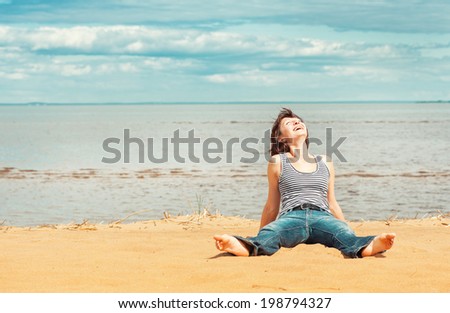 Laughing woman sitting on the beach
