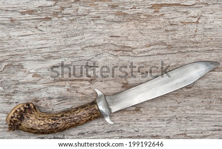 Old knife on the wooden background