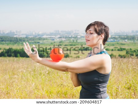 Beautiful plus size woman exercising with ball