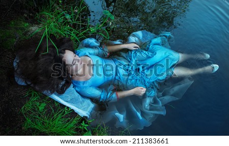 Young beautiful drowned woman lying in the water
