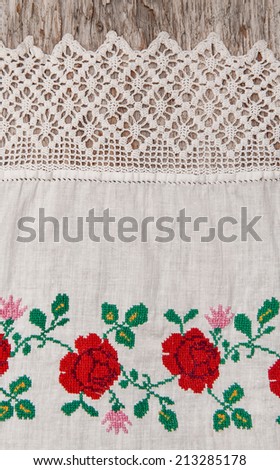 Fabric with embroidery flowers on the old wood