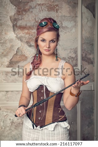 Beautiful steampunk woman with pink hair holding whip