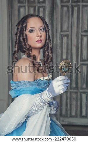 Beautiful medieval woman in blue dress with mirror