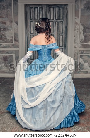 Beautiful medieval woman in long blue dress, back