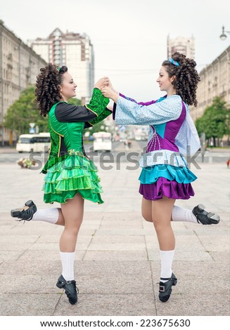 Two women in irish dance dresses  dancing outdoor