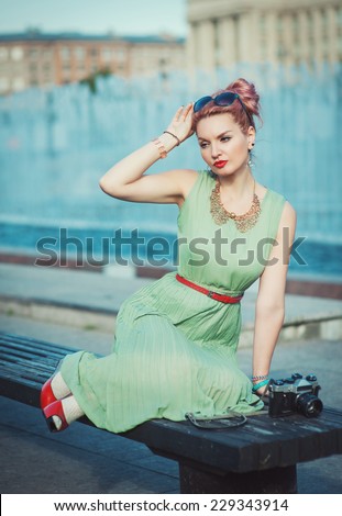 Beautiful girl in vintage clothing with retro camera