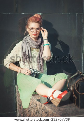 Beautiful girl in vintage clothing with retro camera