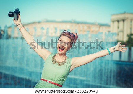 Beautiful happy young girl in vintage clothing with retro camera