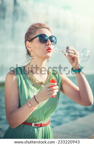 Beautiful young girl in vintage clothing blowing bubbles