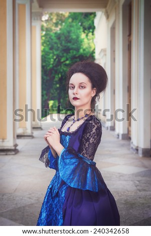 Beautiful young woman in blue medieval dress outdoor