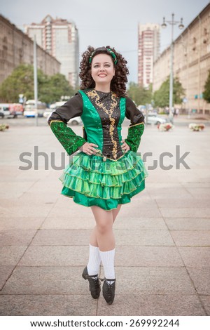 Young woman in irish dance dress and wig posing outdoor
