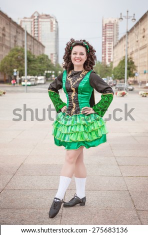 Young woman in irish dance dress and wig posing outdoor