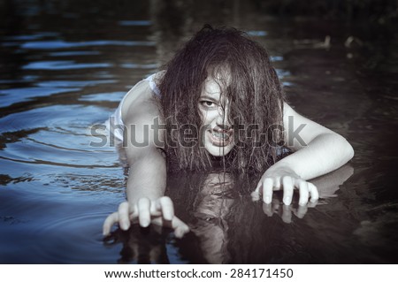 Young beautiful drowned ghost woman in the water outdoor