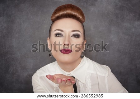 Beautiful woman blowing kiss on the blackboard background