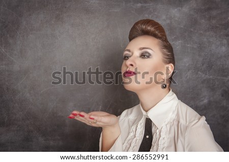 Beautiful woman blowing kiss on the blackboard background