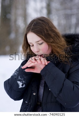 Girl warms her hands by breath