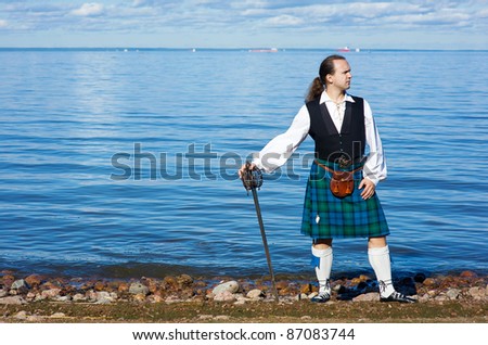 Man In Scottish Costume With Sword Looking A