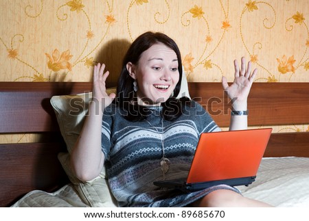 Happy woman with notebook in the bed