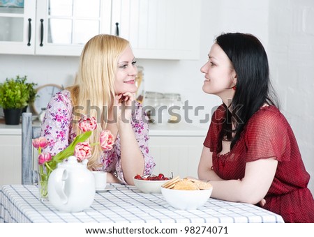 Two beautiful women talking in the kitchen