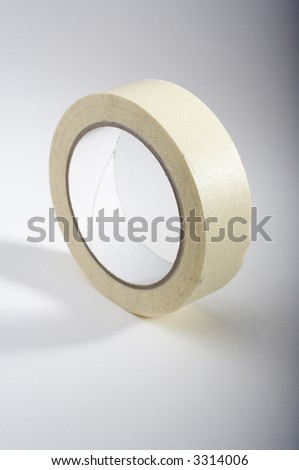 Roll of yellow painters tape on grey background