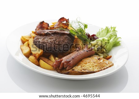 Deep fried potatoes, sausages, beef, bacon and vegetables on dinner plate