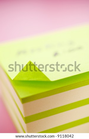 Pile of sticky notes with text over a pink table