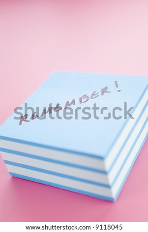Pile of sticky notes with text over a pink table