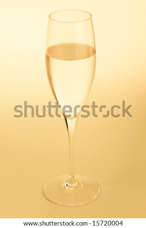 Golden sparkling wine glass over a yellow background