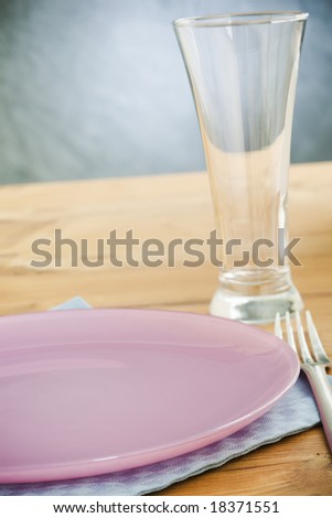 Empty plate and glass on the wooden table