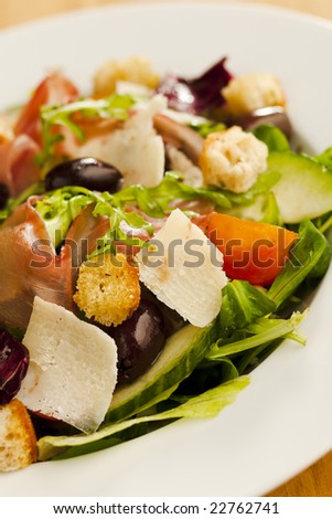 Side salad on the plate (tomato, cucumber, bread, parmesan, ham)