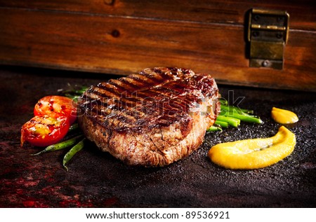 bbq steak on rust iron table with wood box on the background