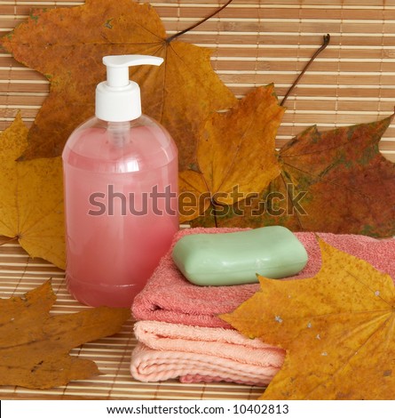 Liquid soap dispenser and soap on bamboo background
