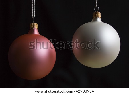 White and pink christmas balls over black background